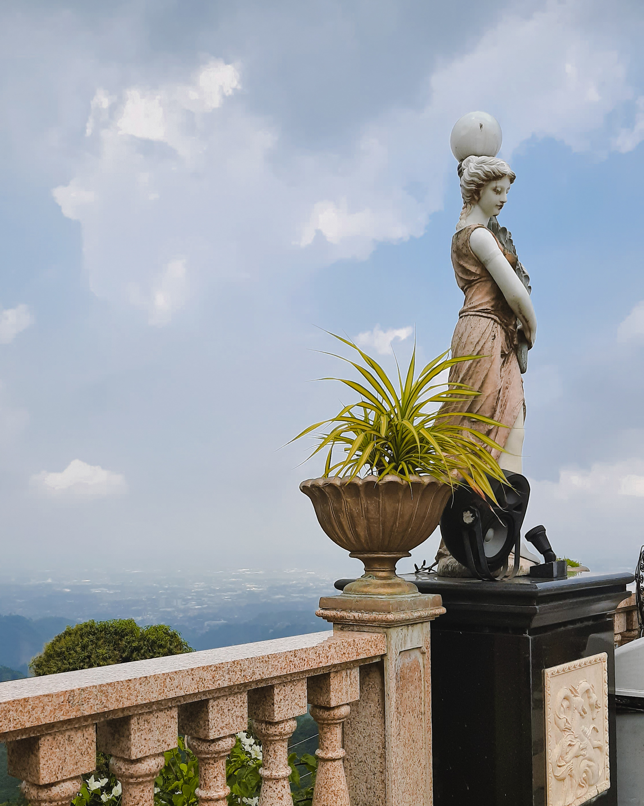 An overlooking view with a sculptural post lamp in the foreground.