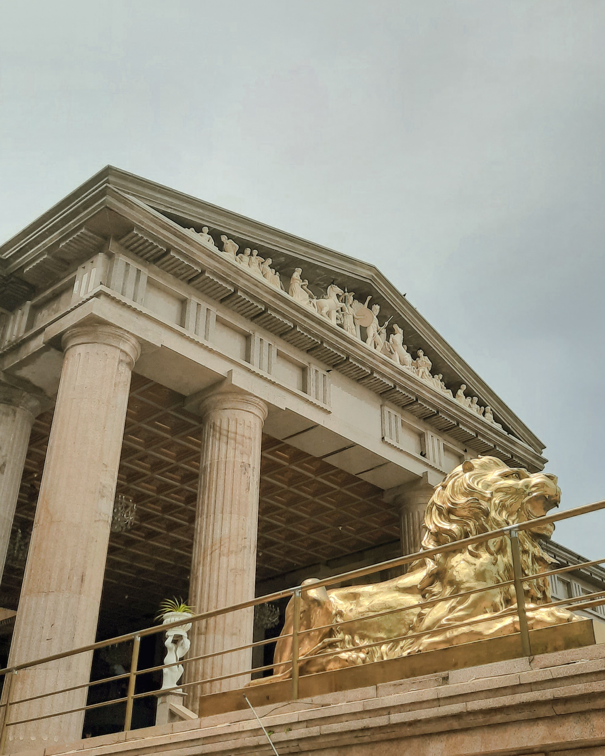 Closer look at the golden lion sculpture, entablature and columns of the classical architecture of Temple of Leah.