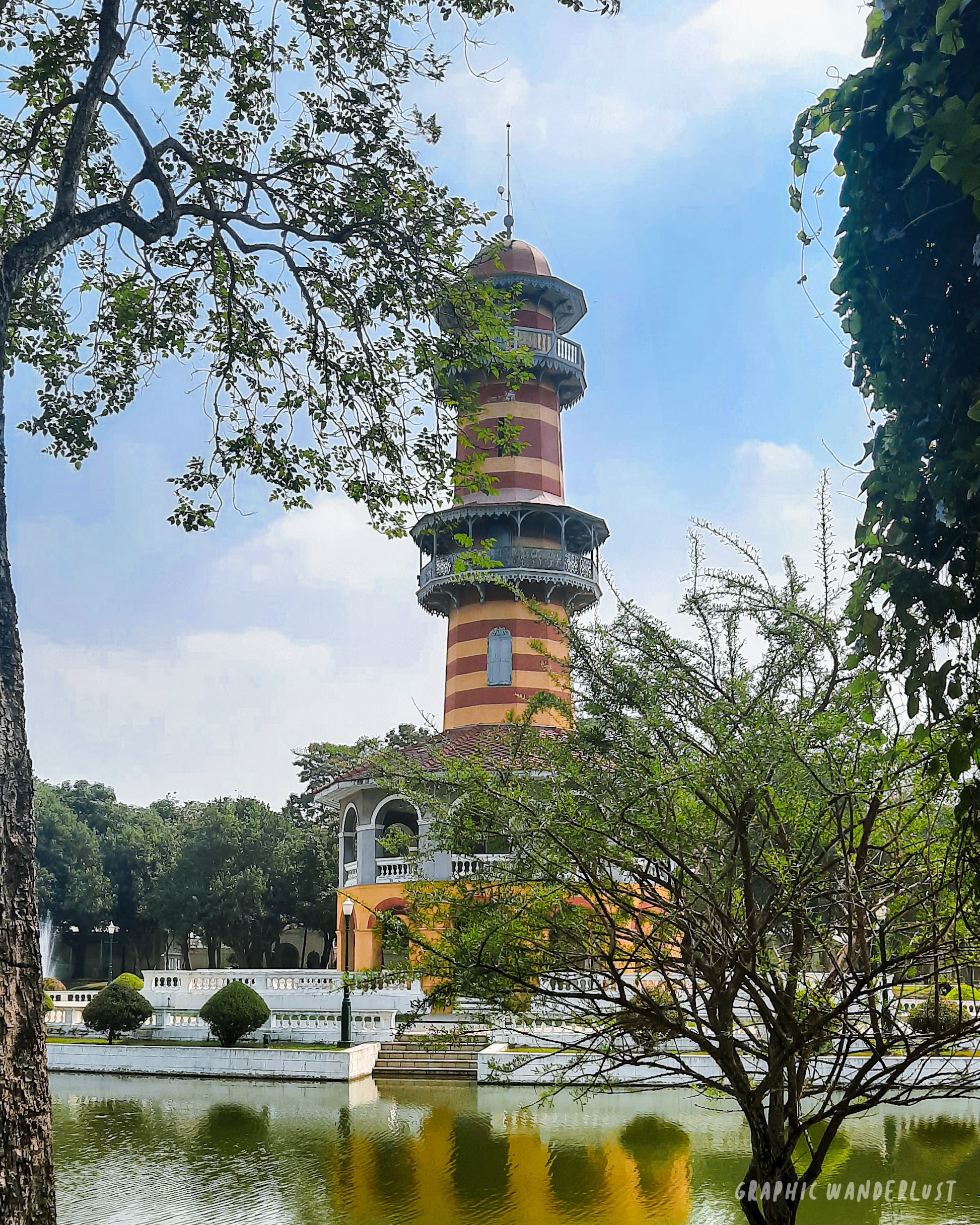 Striped watchtower in Bang Pa-on Palace standing in front of a lake