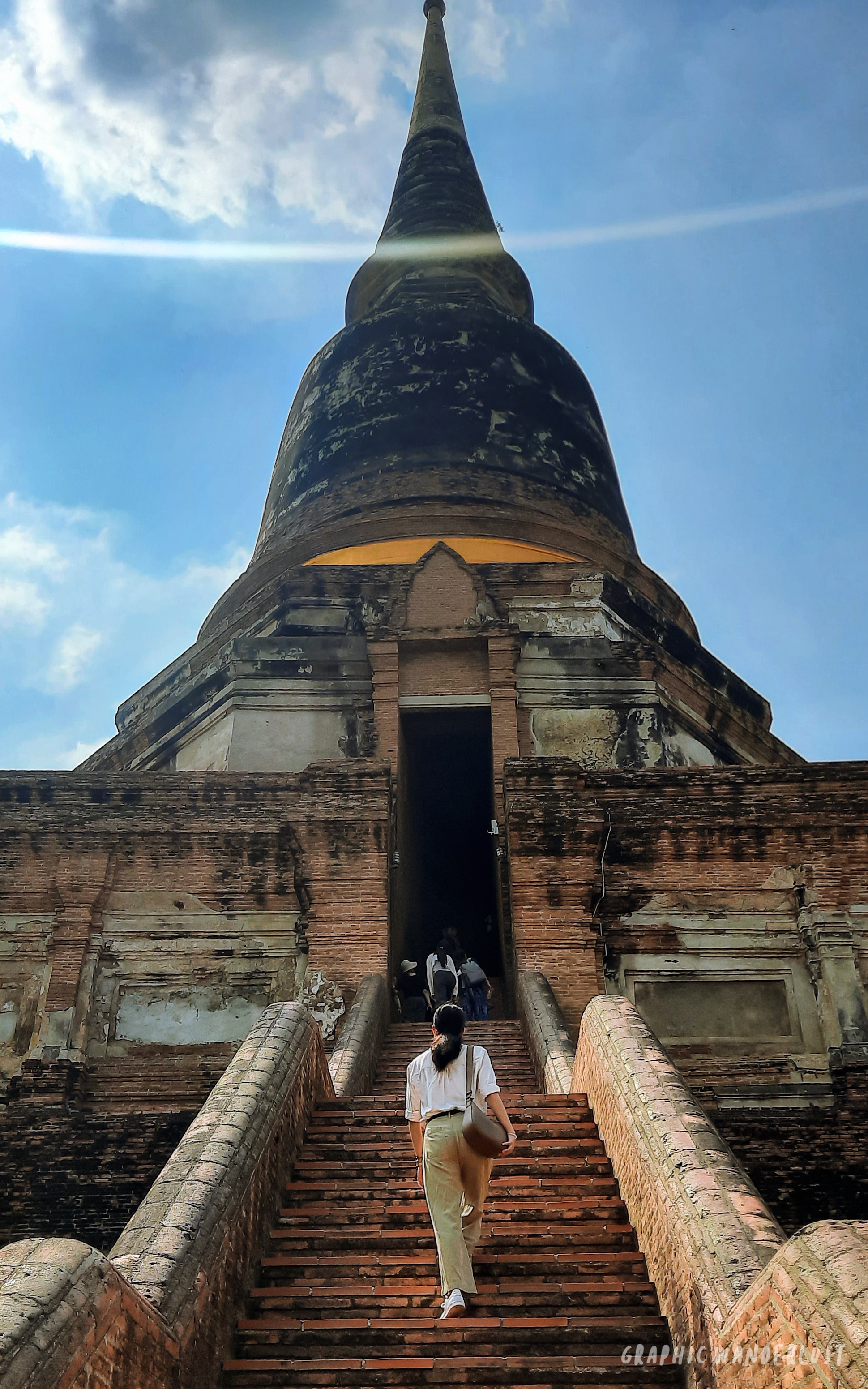 Girl climbing up the stairs going to the top of Wat Yai Chai Mongkhon's main chedi