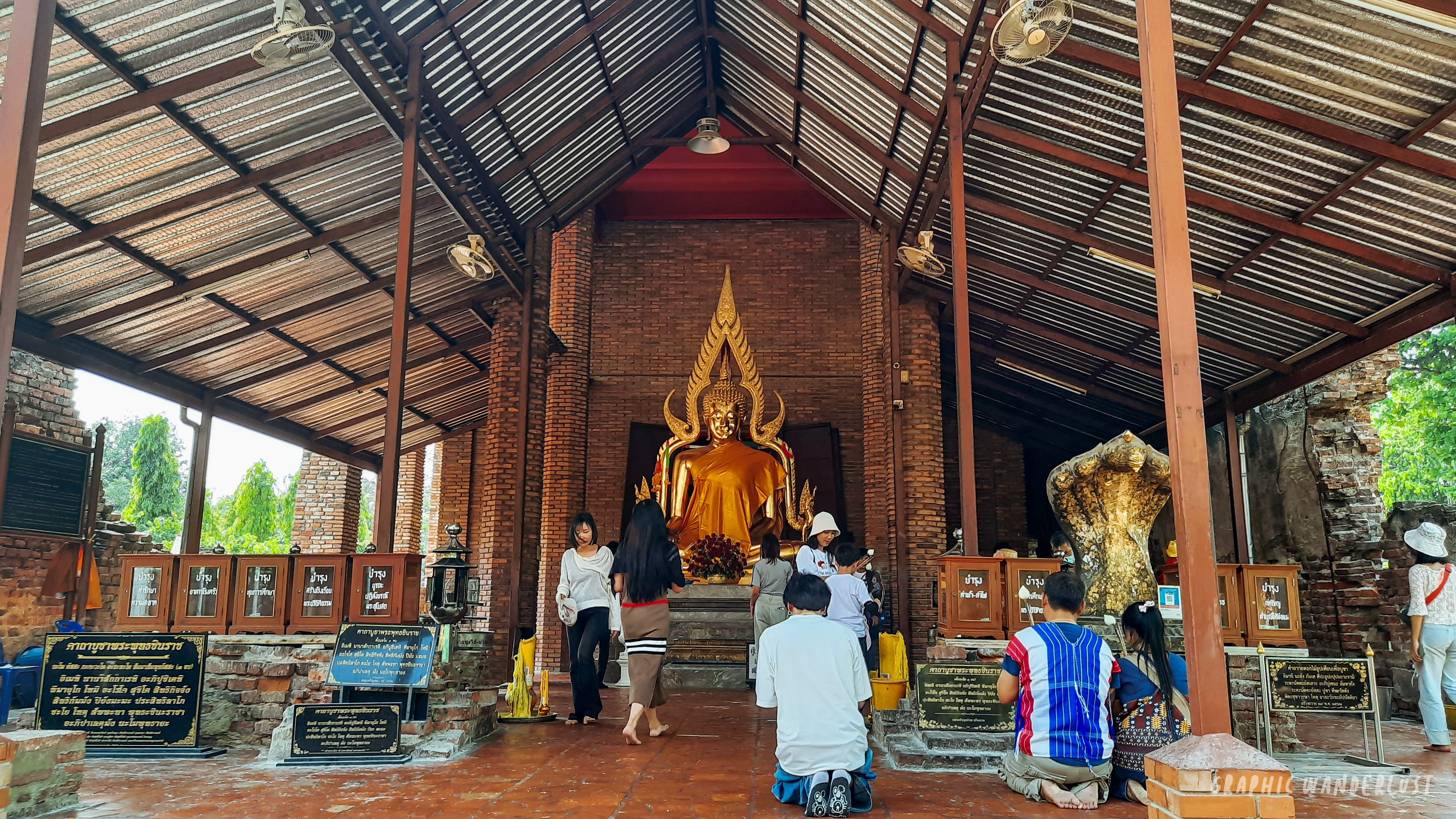 People praying in front of a golden Buddha image in Wat Yai Chai Mongkhon