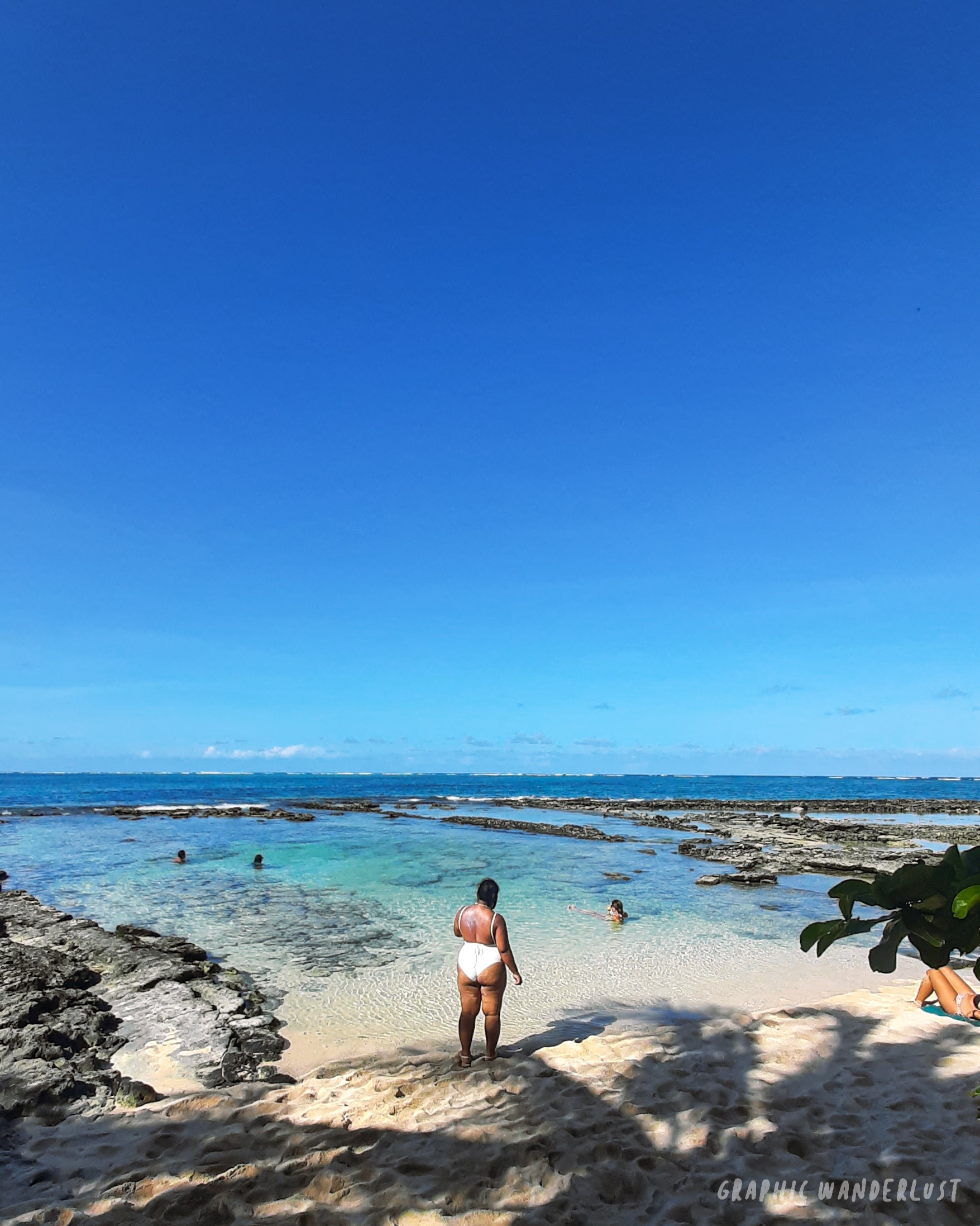 Long shot of Guyam Island's rock bordered shore
