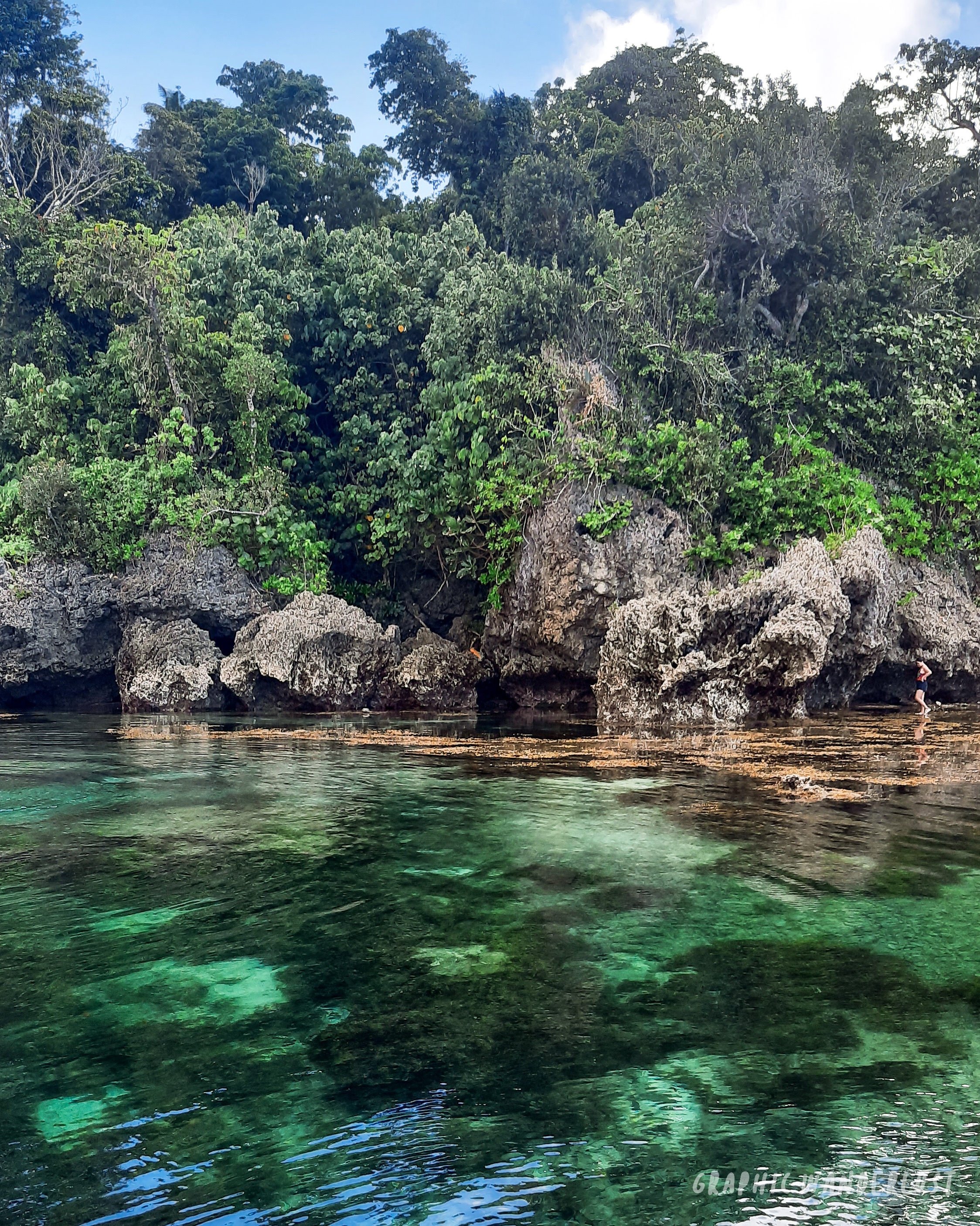 Clear turquoise waters and big rock cliffs of Magpupungko Rock Pool