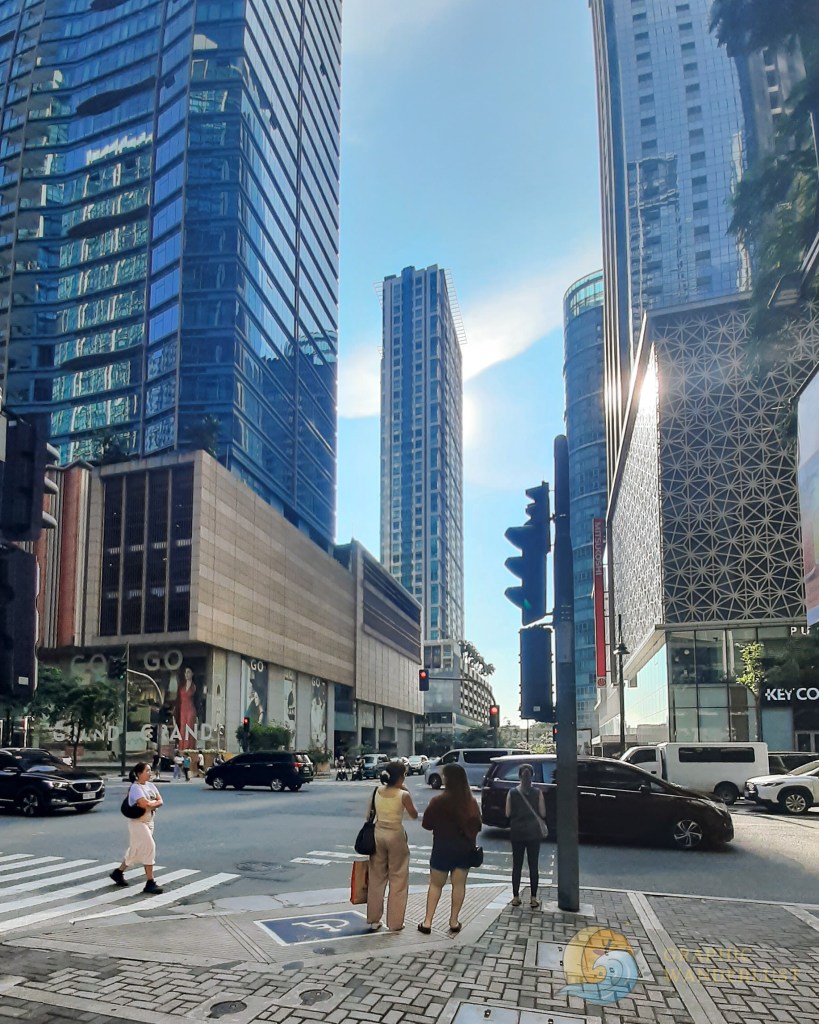 An intersection towered by tall modern buildings in BGC