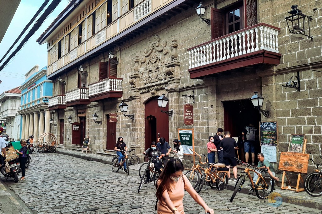Cobblestone street of General Luna in Intramuros, Manila with people renting bamboo bikes