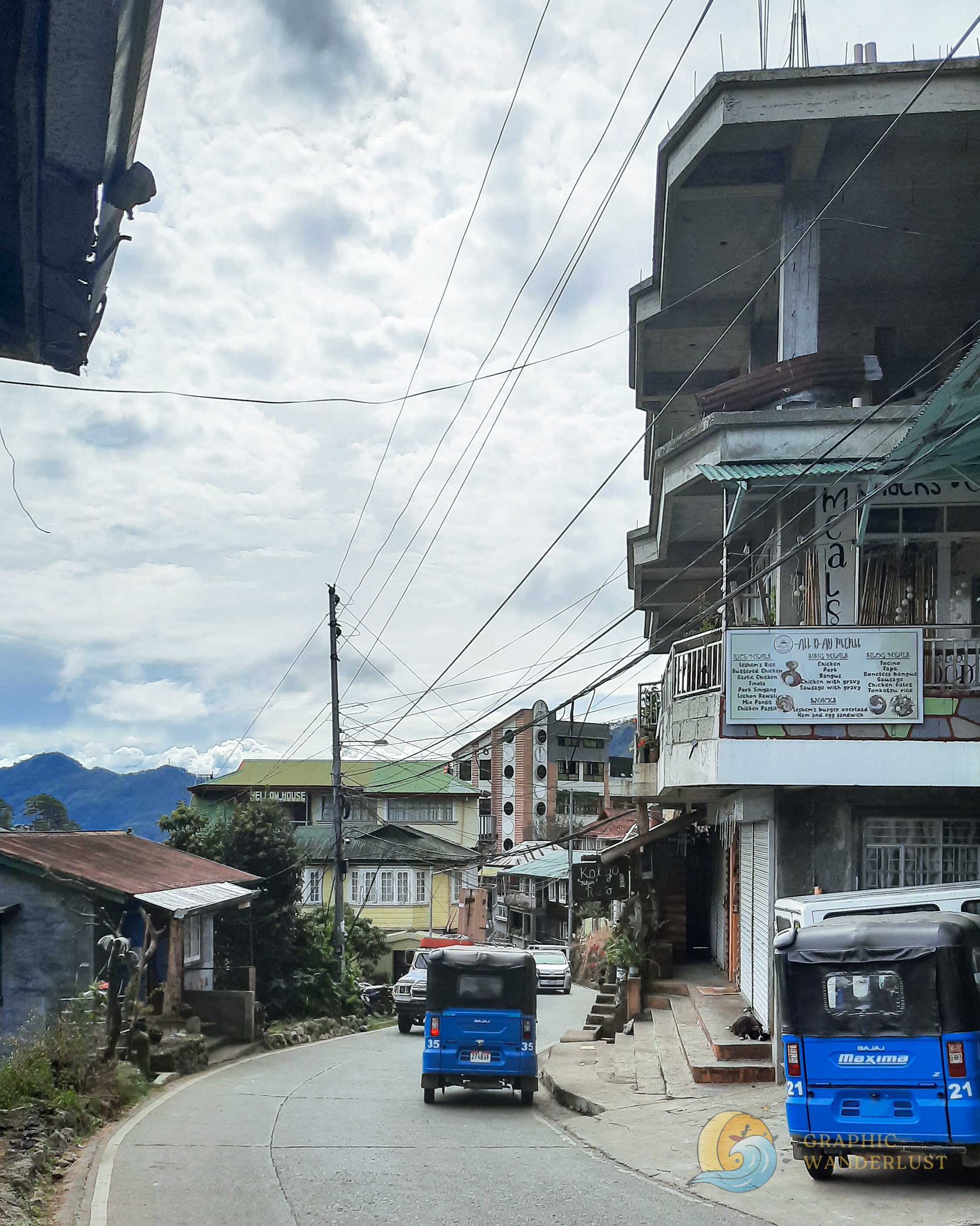 Sloping street and passing vehicles in the mountainous town of Sagada