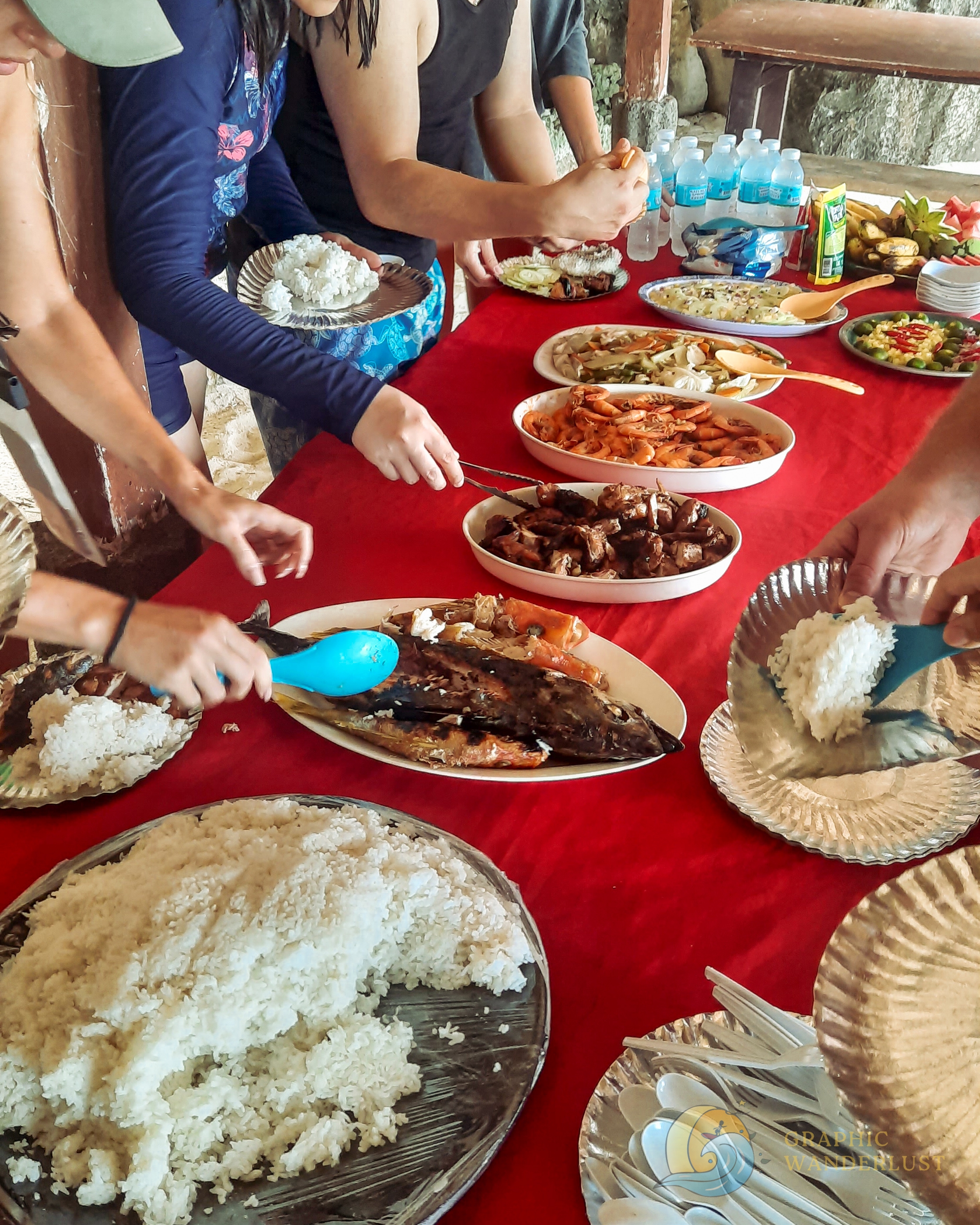 Seafood, meat and vegetable dishes served on the table with people getting from it