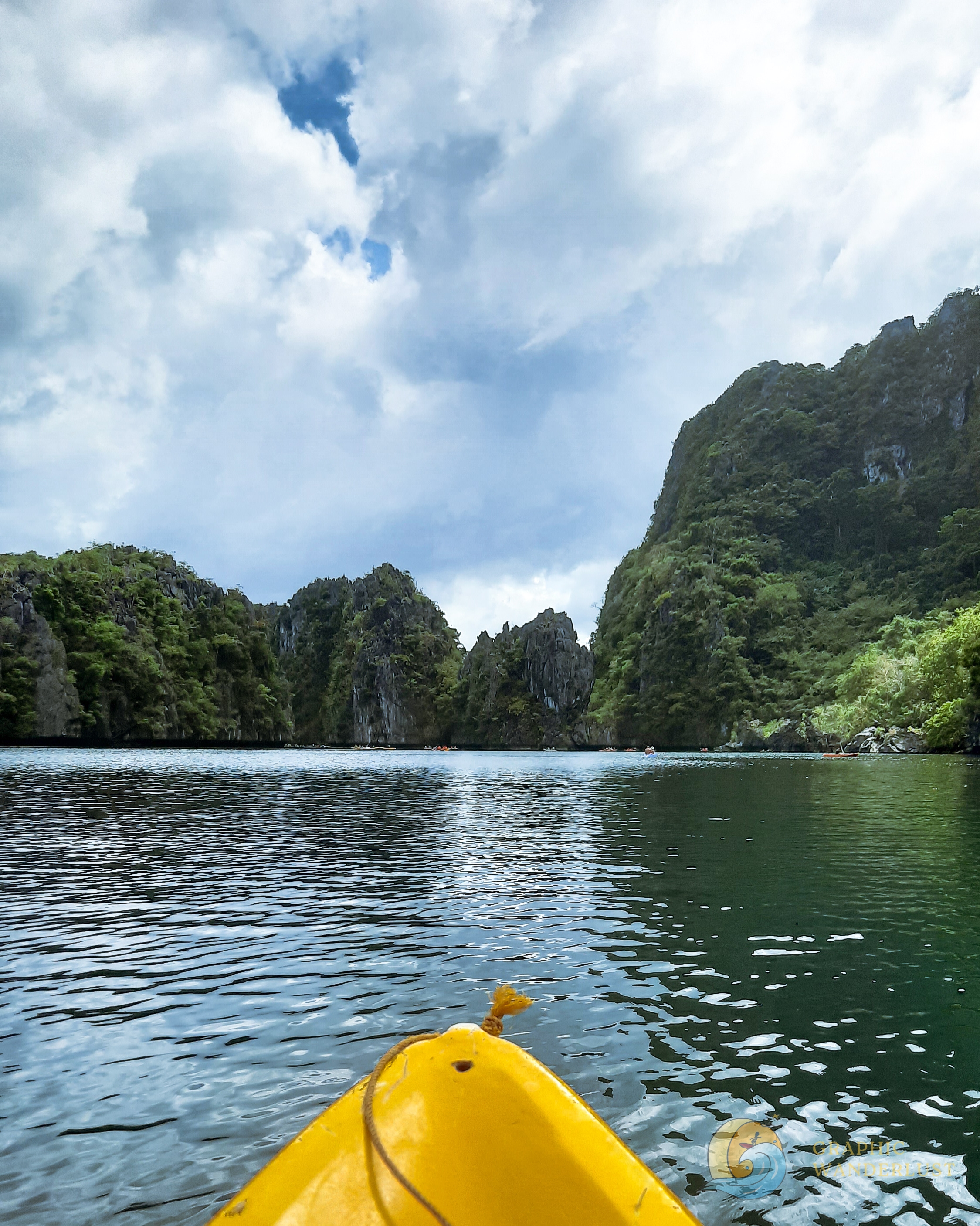 POV of a person kayaking in a lagoon with a view of limestone cliffs