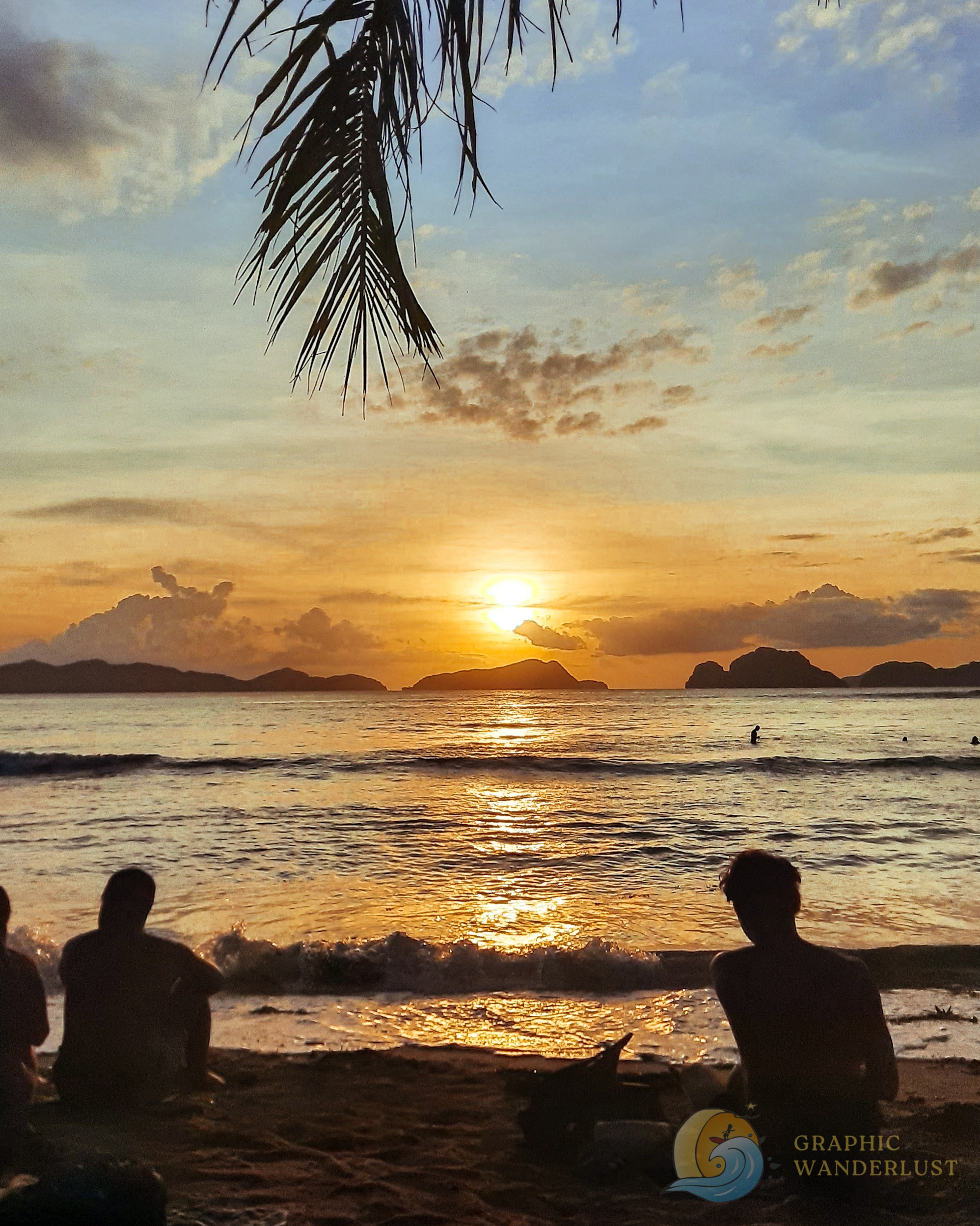 Silhouette of two people sitting by the beach watching a sunset
