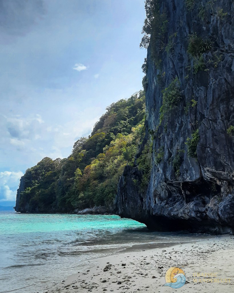 Limestone cliff bordering a turquoise-colored beach
