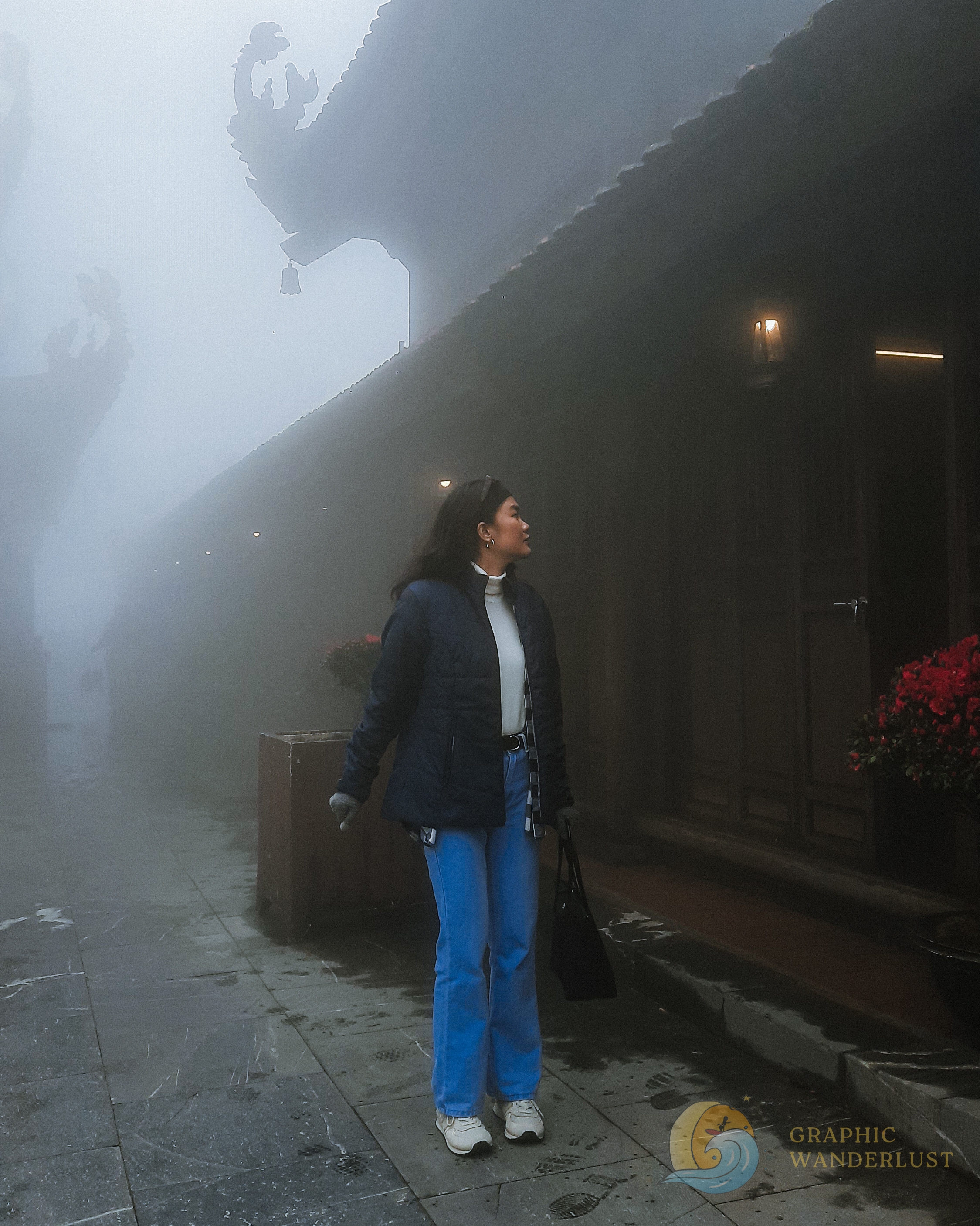 Girl in winter clothes standing infront of a foggy Asian temple