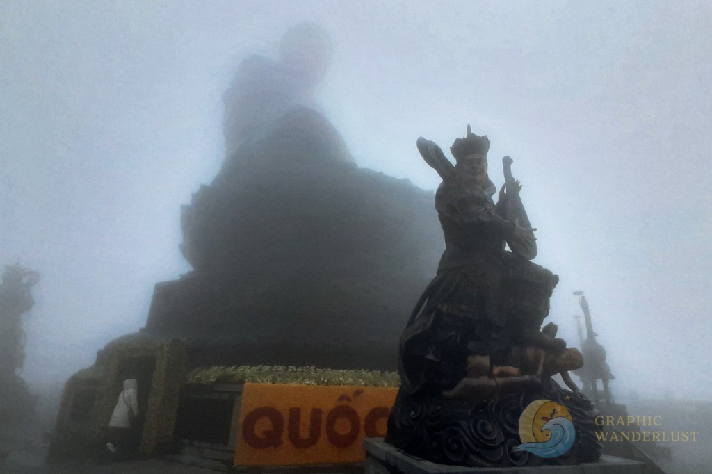 Gigantic Buddha statue in lotus position enveloped in a thick fog as seen from a low angle view