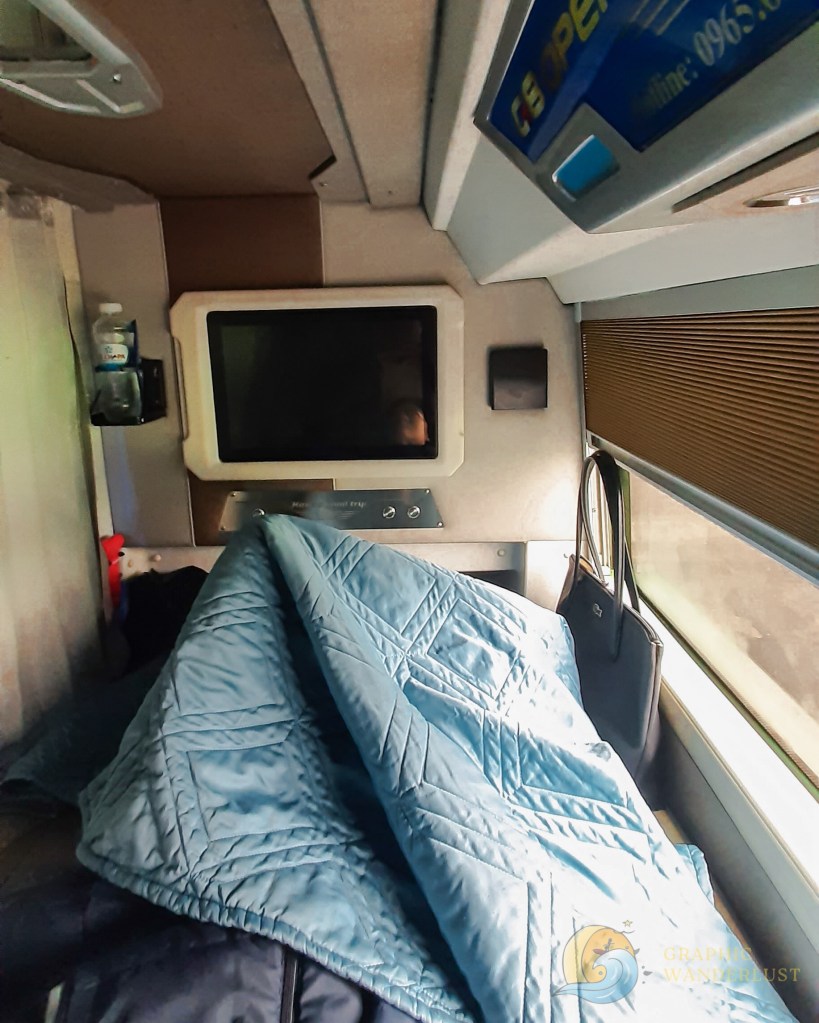 Point-of-view shot of a person lying down in a sleeper bus with a TV infront of her 