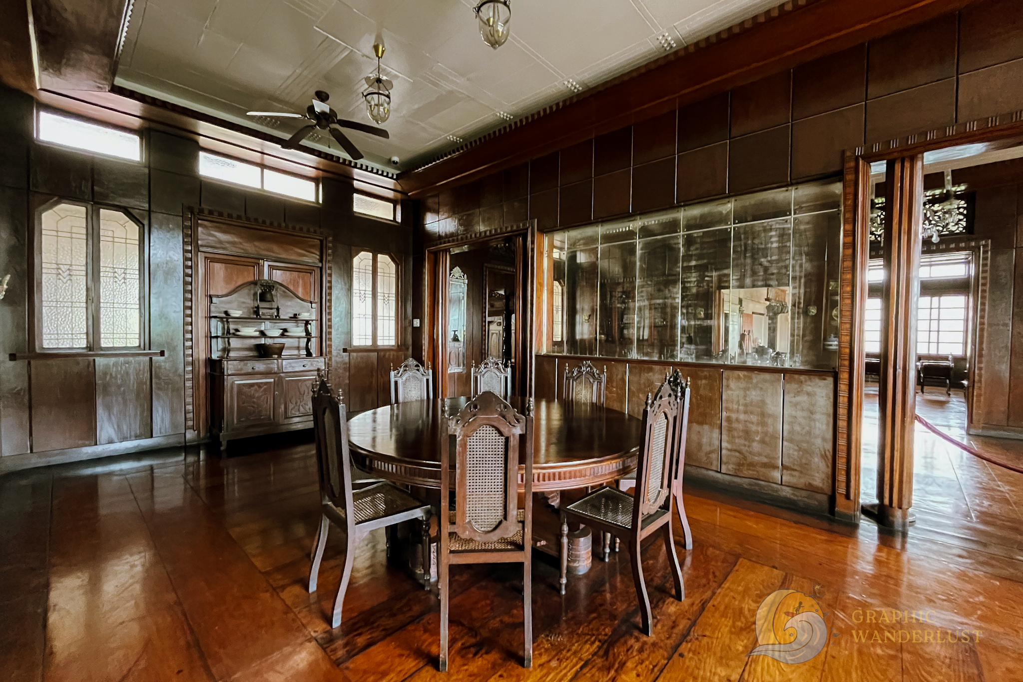 Dining room of a Spanish colonial house in Taal, Batangas adorned with wooded furniture, wooden planked floors and a white Art Deco ceiling.