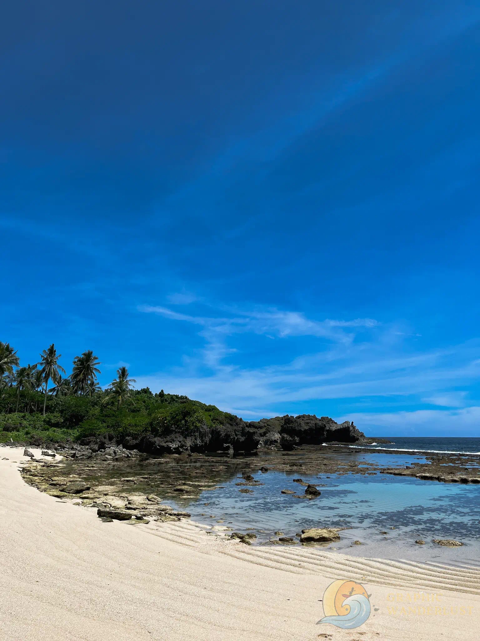 Idyllic tropical scenery of a white-sand beach in North Siargao with a clear blue sky in the background.