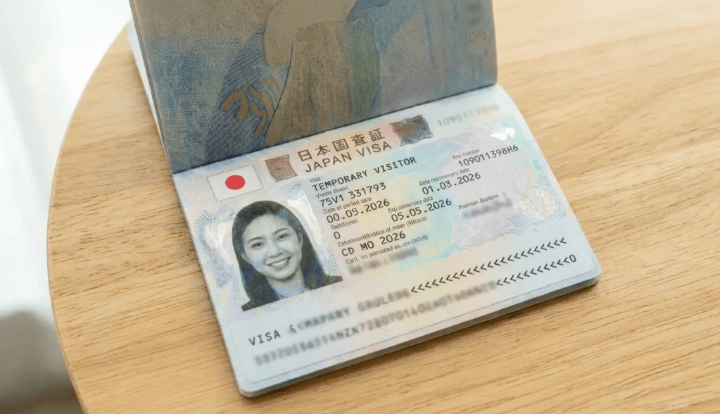 Travel documents including a Philippine passport and Japanese visa application form on a wooden desk.