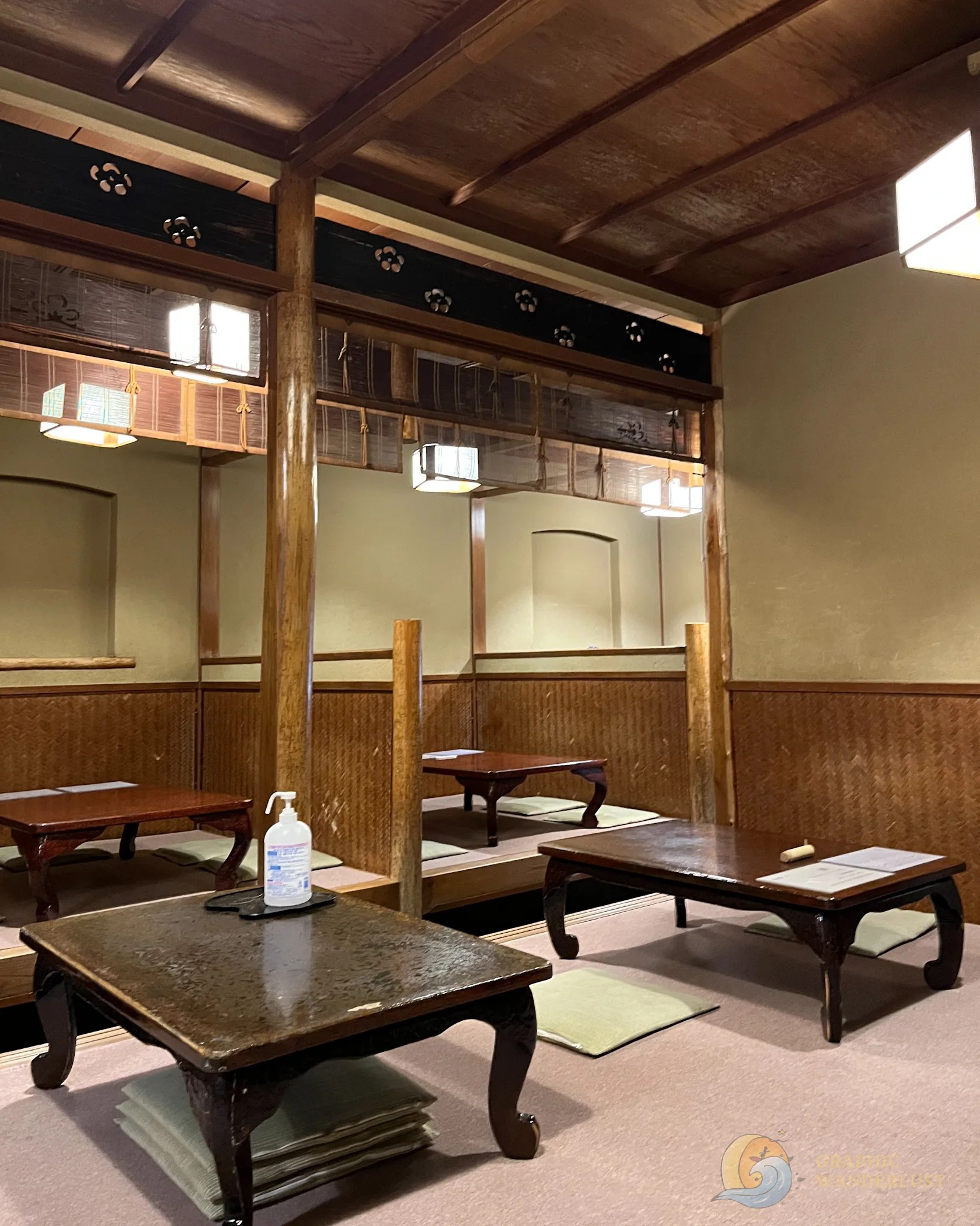 Interior of a Japanese restaurant covered in tatami mats and featuring low tables.