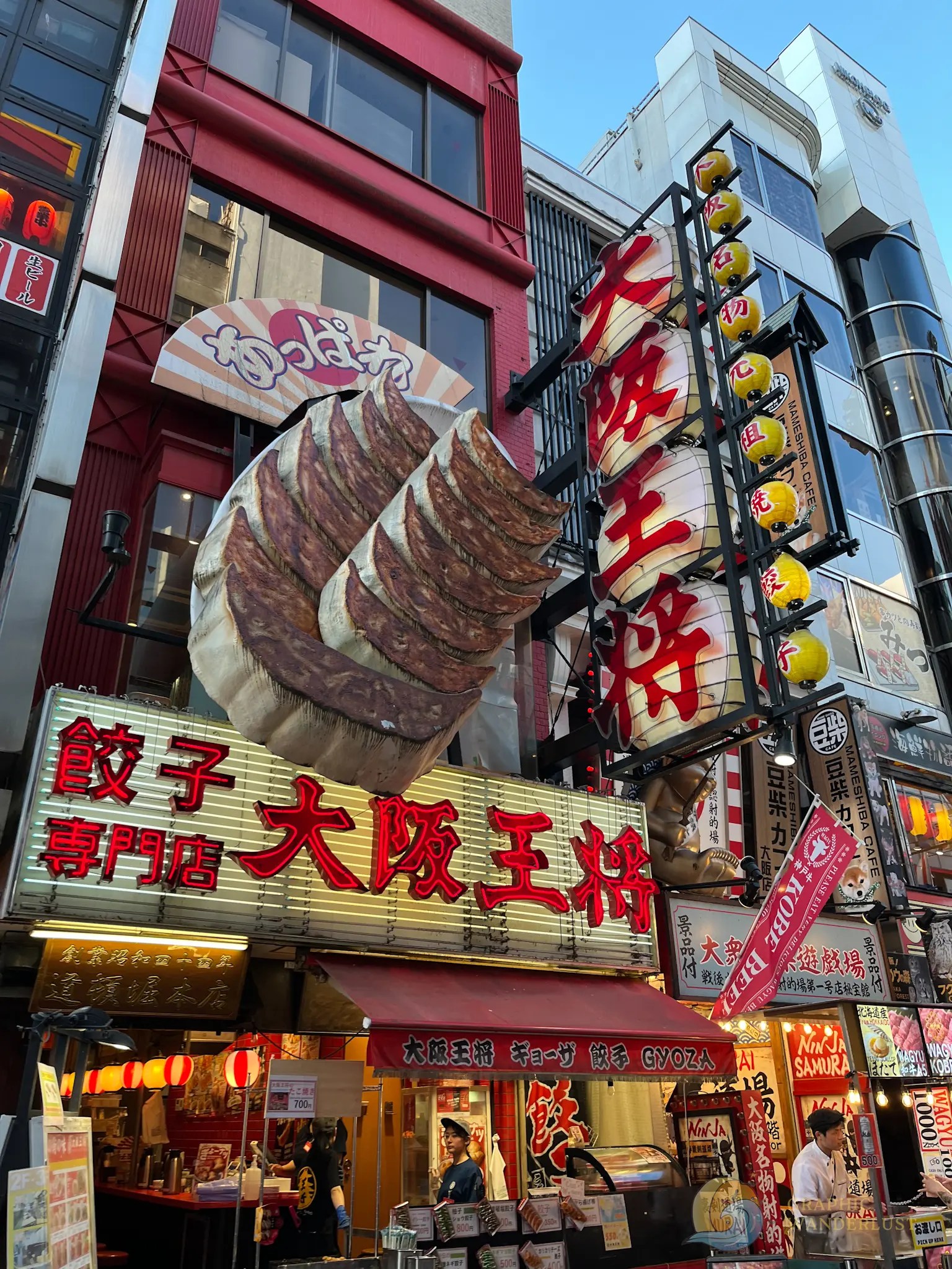 Exterior of a Japanese restaurant with large gyoza sculpture and red lantern signage