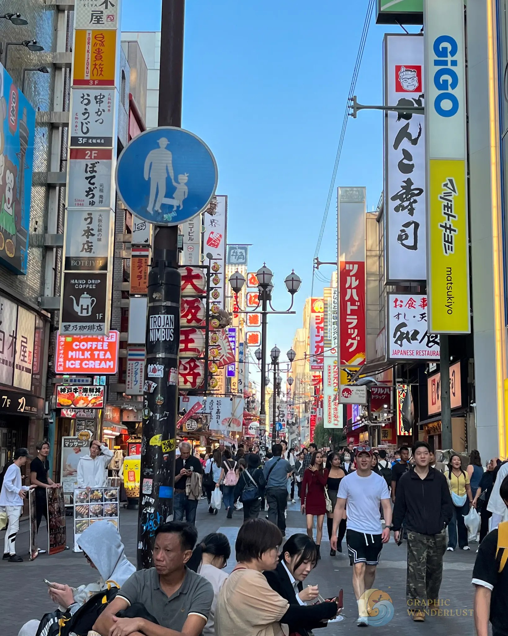 Crowded pedestrian street in Japan with many vertical signs in Japanese and people walking or sitting