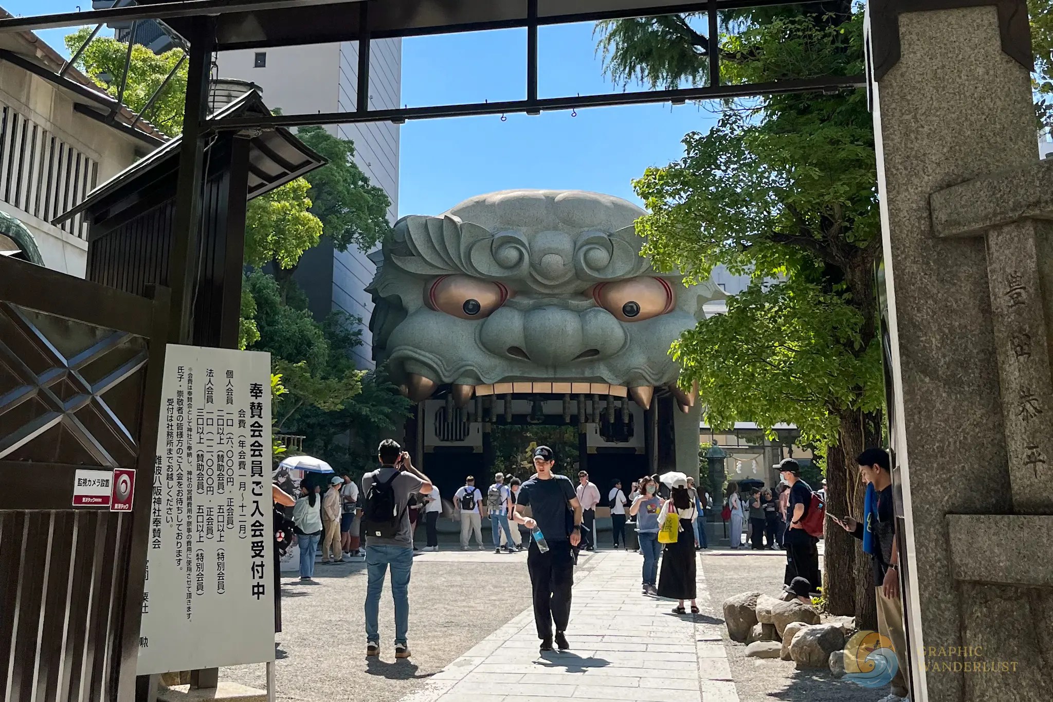 Namba Yasaka Jinja Entrance to a shrine with a large lion head gate and people walking and taking photos