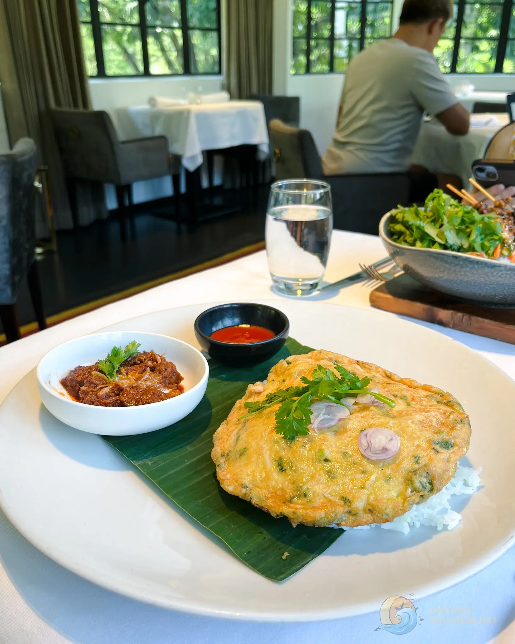 Meal with omelet, lamb rendang, salad, dipping sauce, and rice at a restaurant