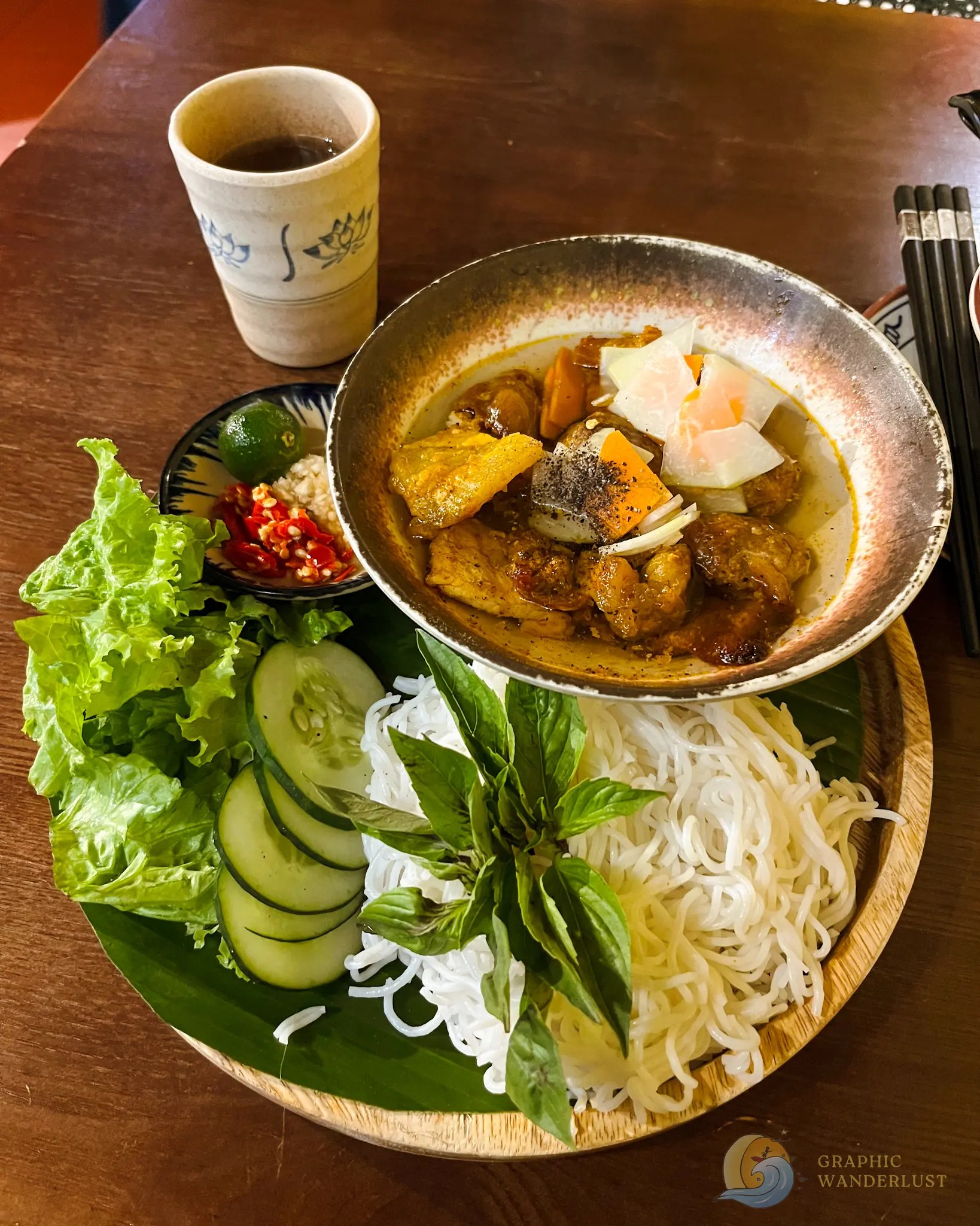 Em Ha Noi Bun Cha Hanoi Vietnamese meal with braised meat, vegetables, herbs, rice noodles, chili, and lime