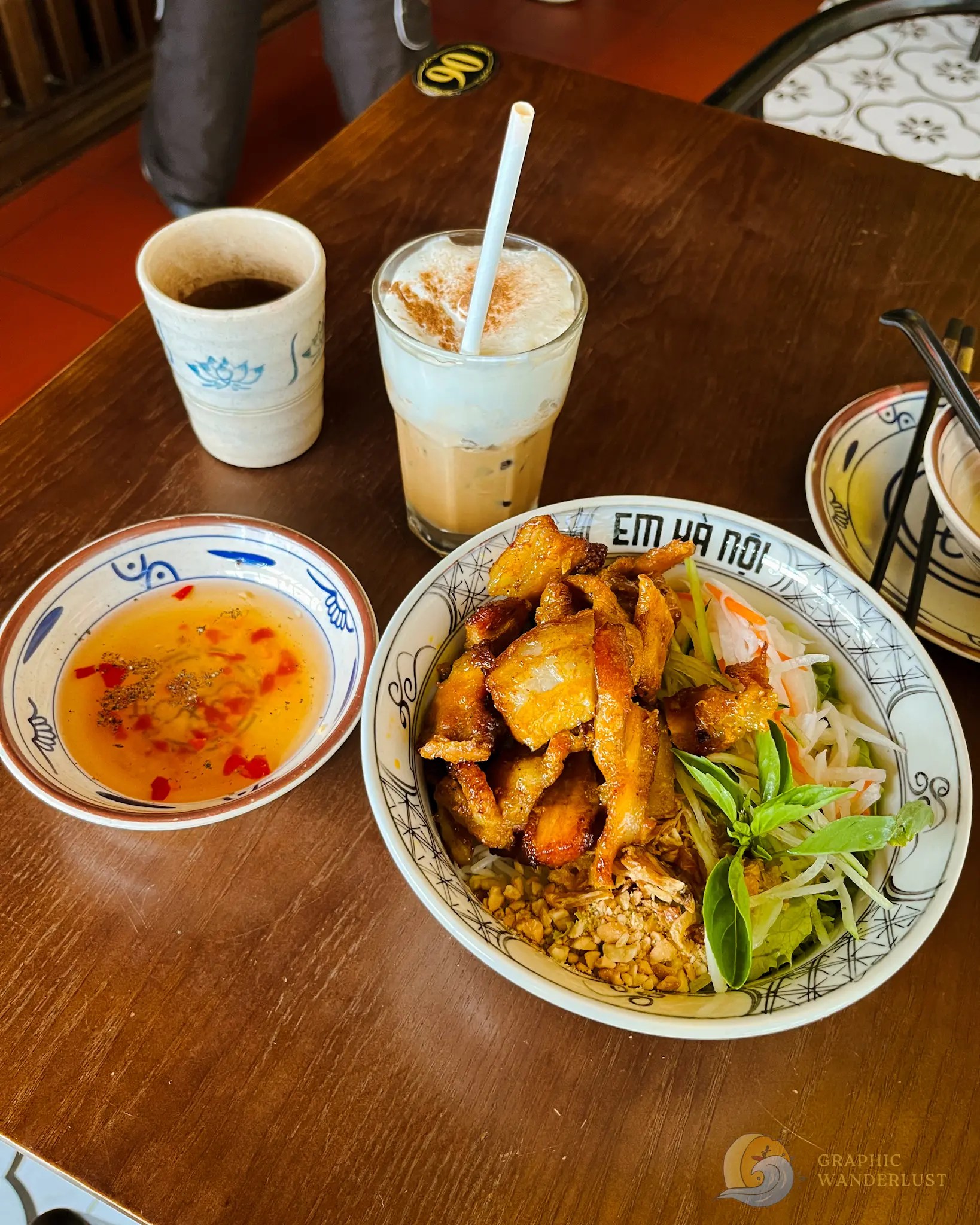 Vietnamese meal with crispy chicken, vegetables, dipping sauce, coffee, and iced milk coffee